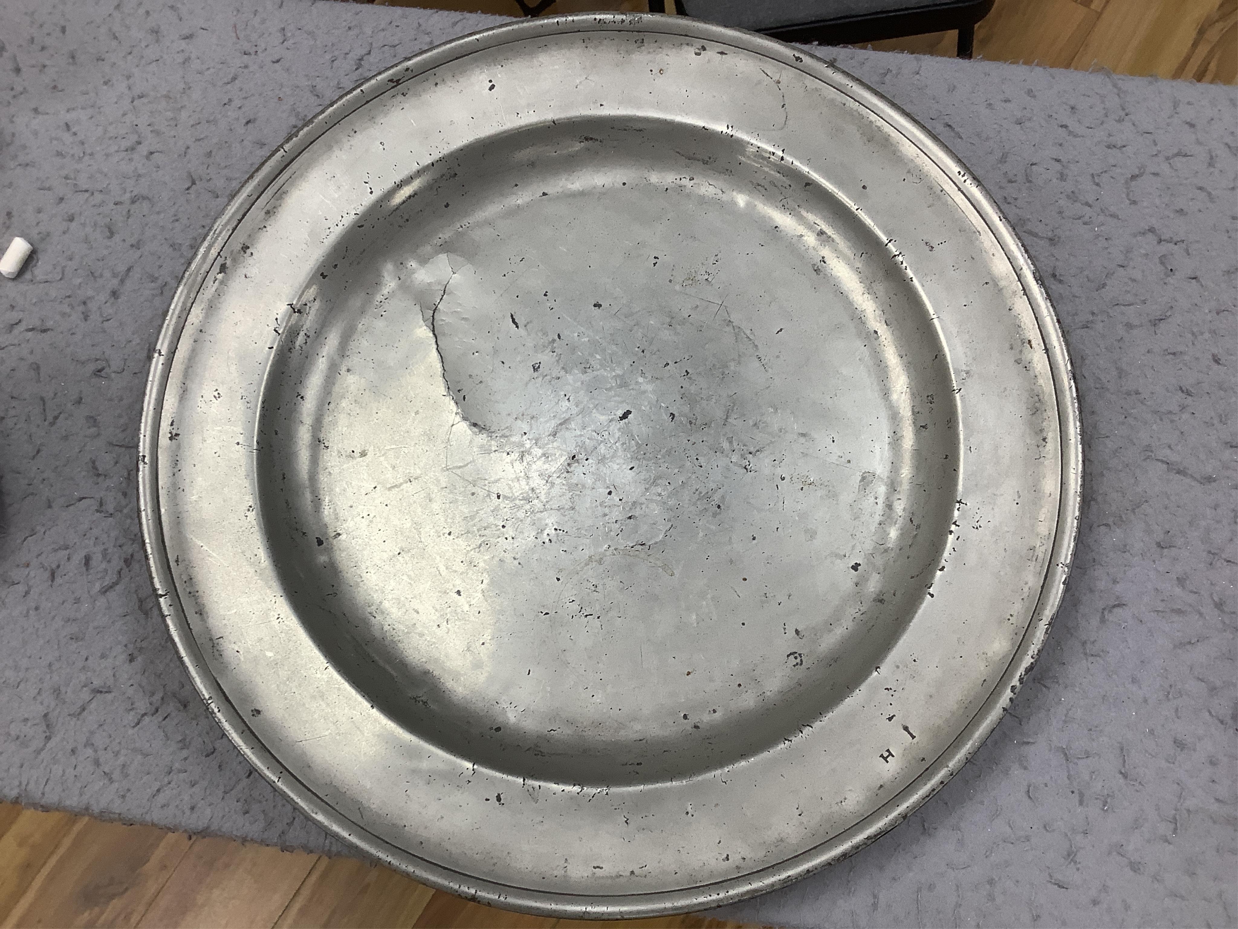 Three pewter chargers, a London touch mark to one, another with rubbed touch marks and ‘WRM’, and another with remains of a touch mark, largest 42.5cm diameter. Condition - fair, worn with damage to one